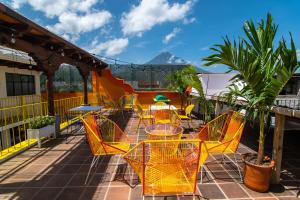 a patio with yellow chairs and tables on a balcony at Why Not Hotel in Antigua Guatemala