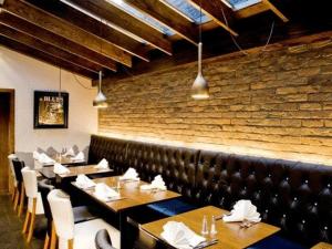 a restaurant with tables and chairs and a brick wall at Artto Hotel in Glasgow