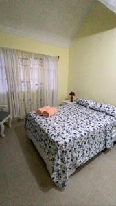 - une chambre dotée d'un lit avec une couverture bleue et blanche dans l'établissement L&Y Punta Cana Beach Apartament, à Punta Cana