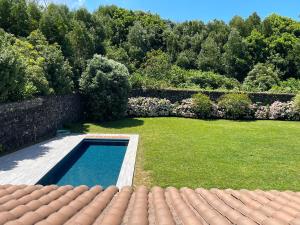 un patio trasero con piscina y jardín en Azores Green Nature, en Rabo de Peixe