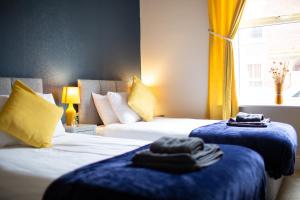 une chambre d'hôtel avec deux lits avec des serviettes dessus dans l'établissement Russell House, Large townhouse spacious and modern with ground floor bedroom and shower room and free parking, à Harraby