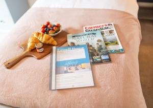 a book and a magazine on a bed with a wooden spoon at Russell House, Large townhouse spacious and modern with ground floor bedroom and shower room and free parking in Harraby