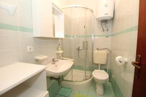 a bathroom with a sink and a toilet and a shower at Apartments by the sea Mandre, Pag - 6284 in Kolan +43 photos