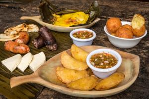 una mesa con platos de comida y tazones de inmersión en Hotel Mariscal Robledo, en Santa Fe de Antioquia