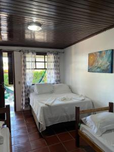 a bedroom with two beds and a window at Pousada Pé Na Areia - ilha do mel in Paranaguá