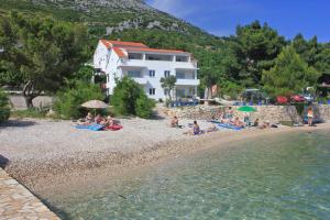 grupa ludzi siedzących na plaży nad wodą w obiekcie Apartments by the sea Kuciste - Perna, Peljesac - 4545 w mieście Kučište