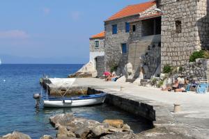 a boat is docked next to a building on the water at Seaside holiday house Lucica, Lastovo - 8348 in Lastovo