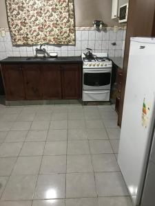 una cocina con estufa y refrigerador en Departamentos Sarmiento, en San Luis