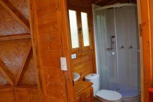 a bathroom with a toilet and a glass shower at Arrecife Glamping in Guatavita
