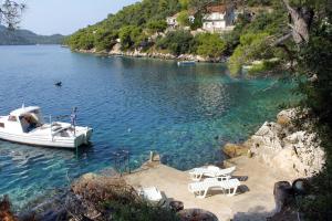a boat docked on a lake with tables and chairs at Apartments by the sea Ubli, Lastovo - 8354 in Ubli
