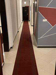 ein roter Teppich führt einen Flur entlang in einem Gebäude in der Unterkunft HOTEL LES ARCADES in Cotonou