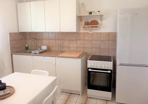 kuchnia z białymi szafkami i piekarnikiem w obiekcie Apartments with a parking space Rukavac, Vis - 8496 w mieście Rukavac +13 zdjęć