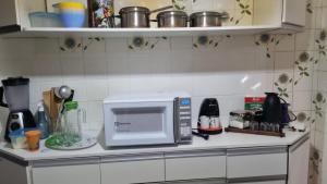 um micro-ondas num balcão numa cozinha em Amplo e confortável. Ar condic, WiFi, TV. Metrô. Tijuca. no Rio de Janeiro