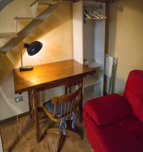 Un escritorio con una lámpara y una silla en una habitación. en Nice apartment on the riverside, en Pisa