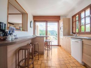 a kitchen with wooden cabinets and a counter with stools at Inviting holiday home in Miremont with garden in Miremont