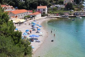 a group of people on a beach with umbrellas at Rooms with a parking space Zaton Mali (Dubrovnik) - 9114 in Zaton