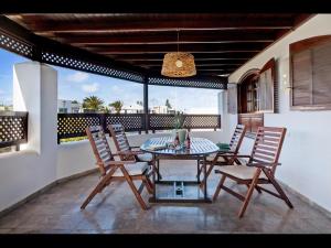 a patio with a table and chairs on a balcony at VILLA HELEN in Playa Blanca