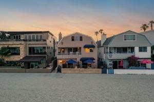 a group of houses on the beach with a building at Bay View II by AvantStay Ocean View Mission Beach Home on the Sand in San Diego