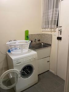 a laundry room with a washing machine and a sink at Doncaster Westfield Home Stay in Doncaster