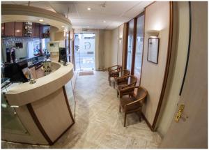 a salon with chairs and a bar in a room at Hôtel Gambetta in Reims