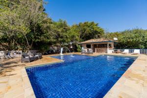 - une piscine dans un jardin avec une fontaine dans l'établissement Hotel Miratlantico Búzios, à Búzios
