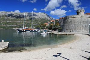 a group of boats in a harbor next to a mountain at Apartments by the sea Korcula - 10054 in Korčula