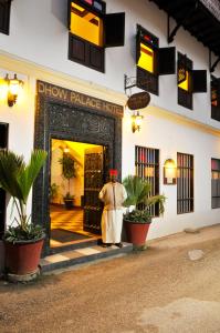 Un uomo in piedi davanti alla porta di un hotel di Dhow Palace Hotel a Zanzibar City