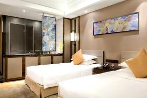 Postel nebo postele na pokoji v ubytování Ramada Foshan Hotel