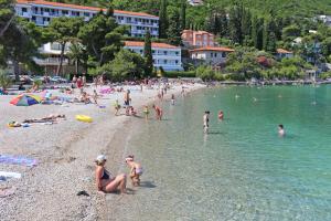 a group of people on a beach in the water at Apartments by the sea Trpanj, Peljesac - 3162 in Trpanj