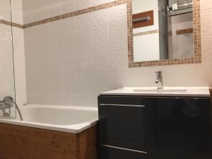 a bathroom with a sink and a bath tub at Studio Plagne Aime 2000, 1 pièce, 4 personnes - FR-1-181-2591 in Aime La Plagne
