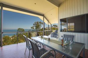 a table and chairs on a balcony with a view of the ocean at Tangalooma Holiday House in Tangalooma