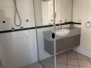 a bathroom with a sink and a shower at Tangalooma Holiday House in Tangalooma +12 photos