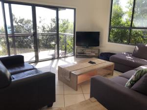 a living room with two couches and a tv at Tangalooma Holiday House in Tangalooma