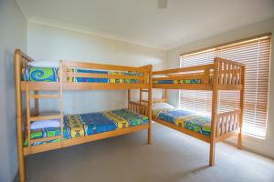 a bedroom with two bunk beds and a window at Tangalooma Holiday House in Tangalooma