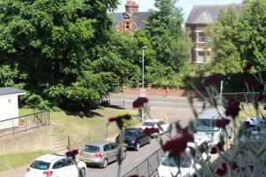 eine Gruppe von Autos, die auf einer Stadtstraße geparkt sind in der Unterkunft 2 Bedroom Flat in Luton City Centre in Luton