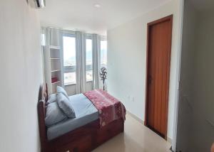 a bedroom with a bed and a window at PRAIA GRANDE LOFT DUPLEX in Arraial do Cabo