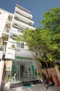 a hotel with a tree in front of a building at Pao Hotel in Hue