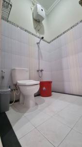 a bathroom with a toilet and a phone on the wall at Oemah Wisata RinginSari -Full House, 5 Bed Rooms- in Kalasan