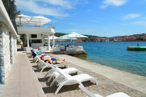 a group of people laying on lounge chairs on the beach at Apartments by the sea Vela Luka, Korcula - 159 in Vela Luka