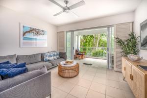 una sala de estar con un sofá y una mesa en Beach Club Palm Cove Serenity Wing 3 Bed Penthouse, en Palm Cove