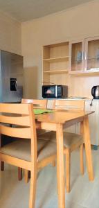 a wooden table with two chairs and a microwave at Fully Furnished Apartment in Chililabombwe in Chililabombwe