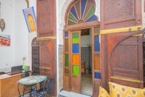 een kamer met een bureau en een houten deur bij Dar Lalamoune in Fès