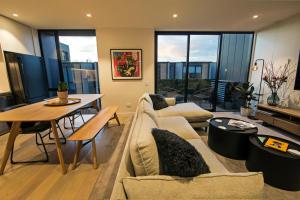 a living room with a couch and a table at Funk in the City - Luxury Laneway Apartment with Single Garage in Christchurch