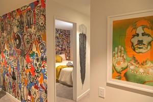 a room with colorful paintings on the walls at Funk in the City - Luxury Laneway Apartment in Christchurch