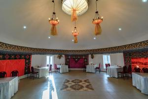 a banquet hall with tables and chairs and chandeliers at Yurt camp Meiman Ordo in Bokonbayevo