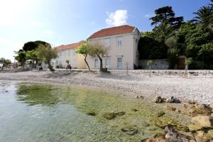a house on a beach next to a body of water at Seaside holiday house Orebic, Peljesac - 11853 in Orebić
