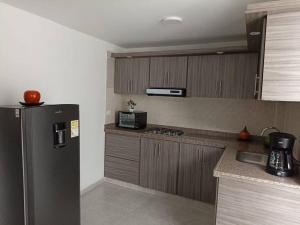 una cucina con frigorifero nero e lavandino di Agradable casa para alojamiento completo CURITI a Curití