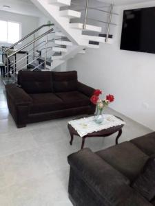 un soggiorno con divano e tavolo con fiori di Agradable casa para alojamiento completo CURITI a Curití