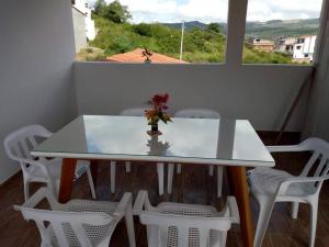 a white table with white chairs and a vase with flowers on it at Agradable casa para alojamiento completo CURITI in Curití