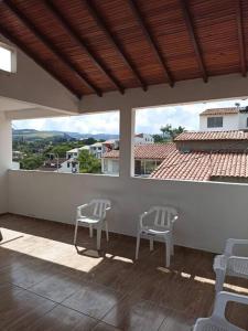 2 sedie su un portico con vista su un edificio di Agradable casa para alojamiento completo CURITI a Curití